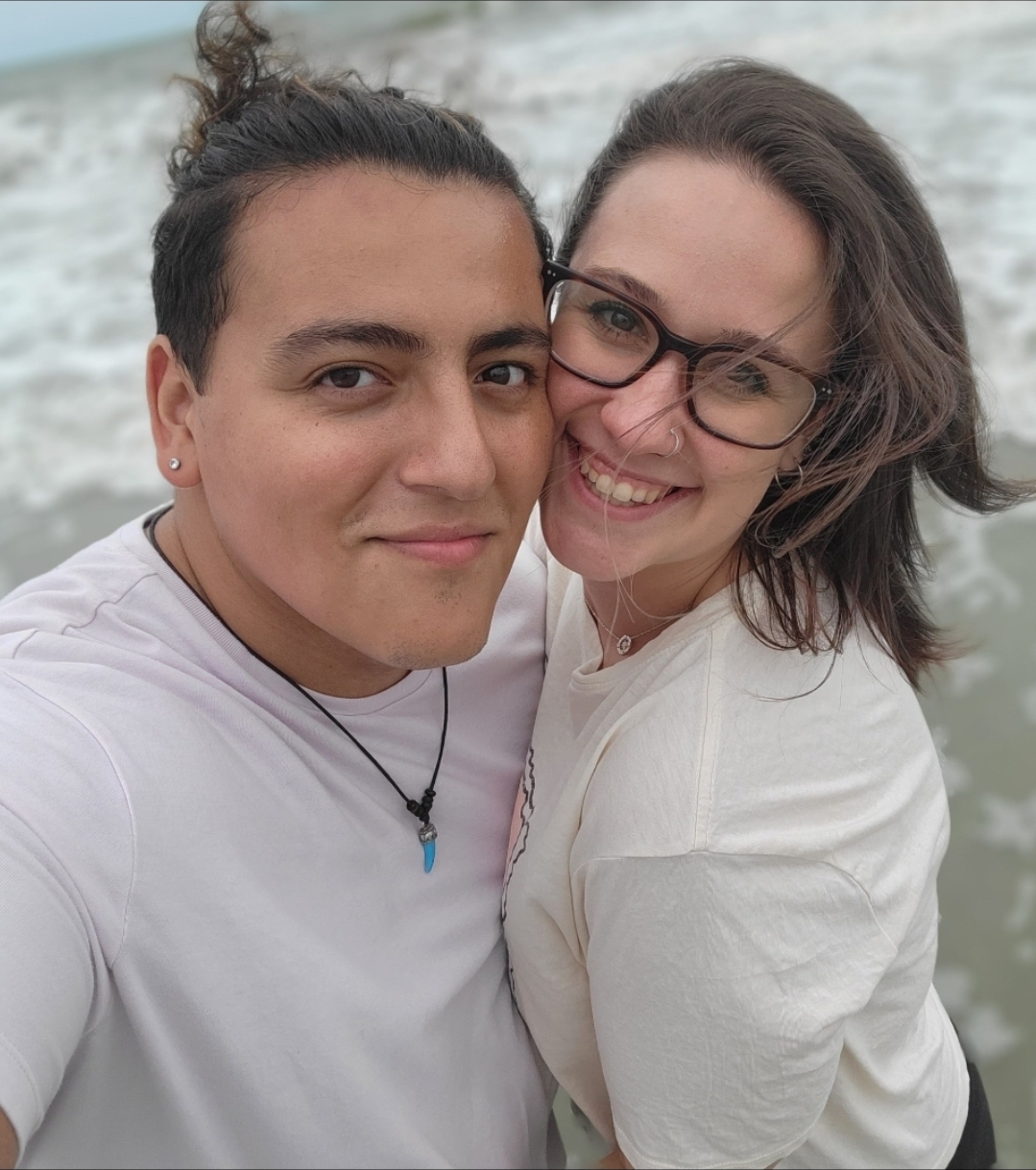 Julian and Elizabeth smiling together by the ocean